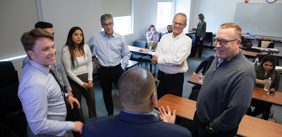 Donors, students and faculty mingle in a classroom