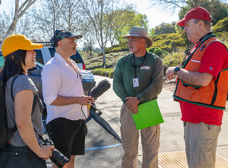 Photo of CSUEB students speaking with professor Luther Strayer and USGS scientist.