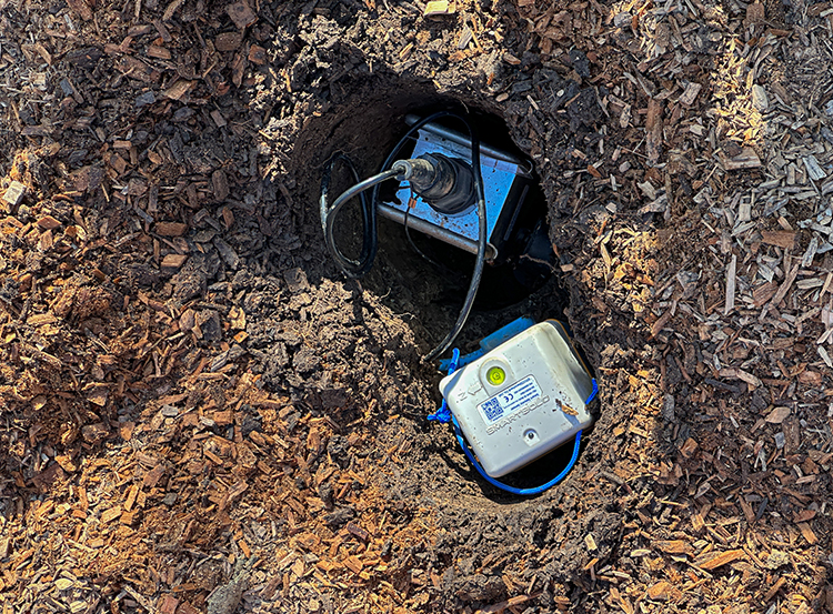 Close-up image of an earthquake sensor in a hole.