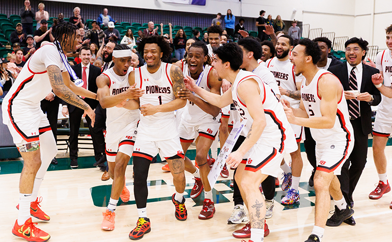 Pioneer Men's Basketball players in celebration post-win.