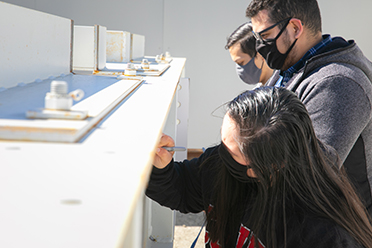 Three students sign beam