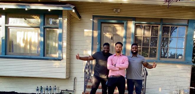 Three men stand outside a home