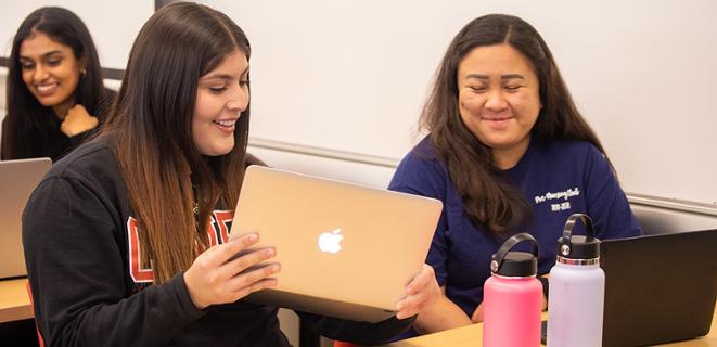Two students looking at a laptop.