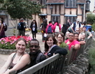 15 persons sitting on a long bench.