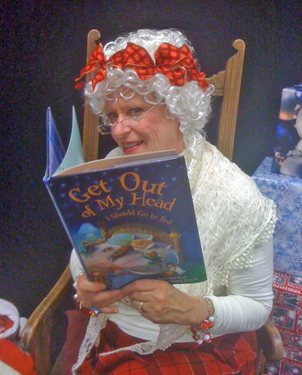 Mrs. Claus (Susan Pace-Koch '04) reads to children from her first book, "Get Out of My Head, I Should Go to Bed" (courtesy of Susan Pace-Koch