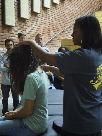 Melissa Polk, medical student at Touro University, gives a demonstration of osteopathic manipulative medicine at recent PHAP symposium. By: Jill Hardeman
