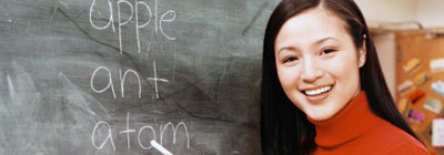 Woman holding chalk next to chalk board