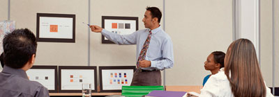 A man in front of a black board teaching students.