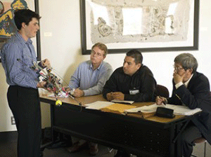 A competitor in a 2013 CSU Research event is shown explaining his research for faculty jurors. (by: CSU)