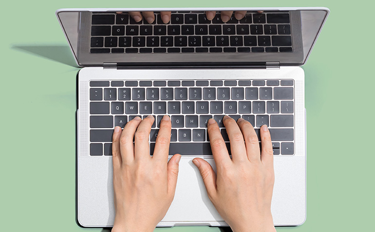 hands typing on laptop computer
