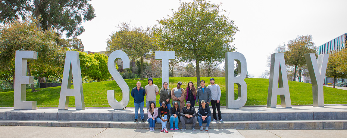 PHAP students in front of East Bay letters.