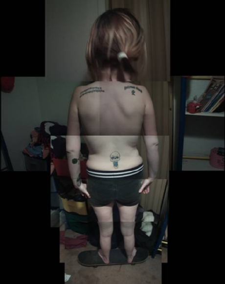 person with tattoos from behind standing on a skateboard
