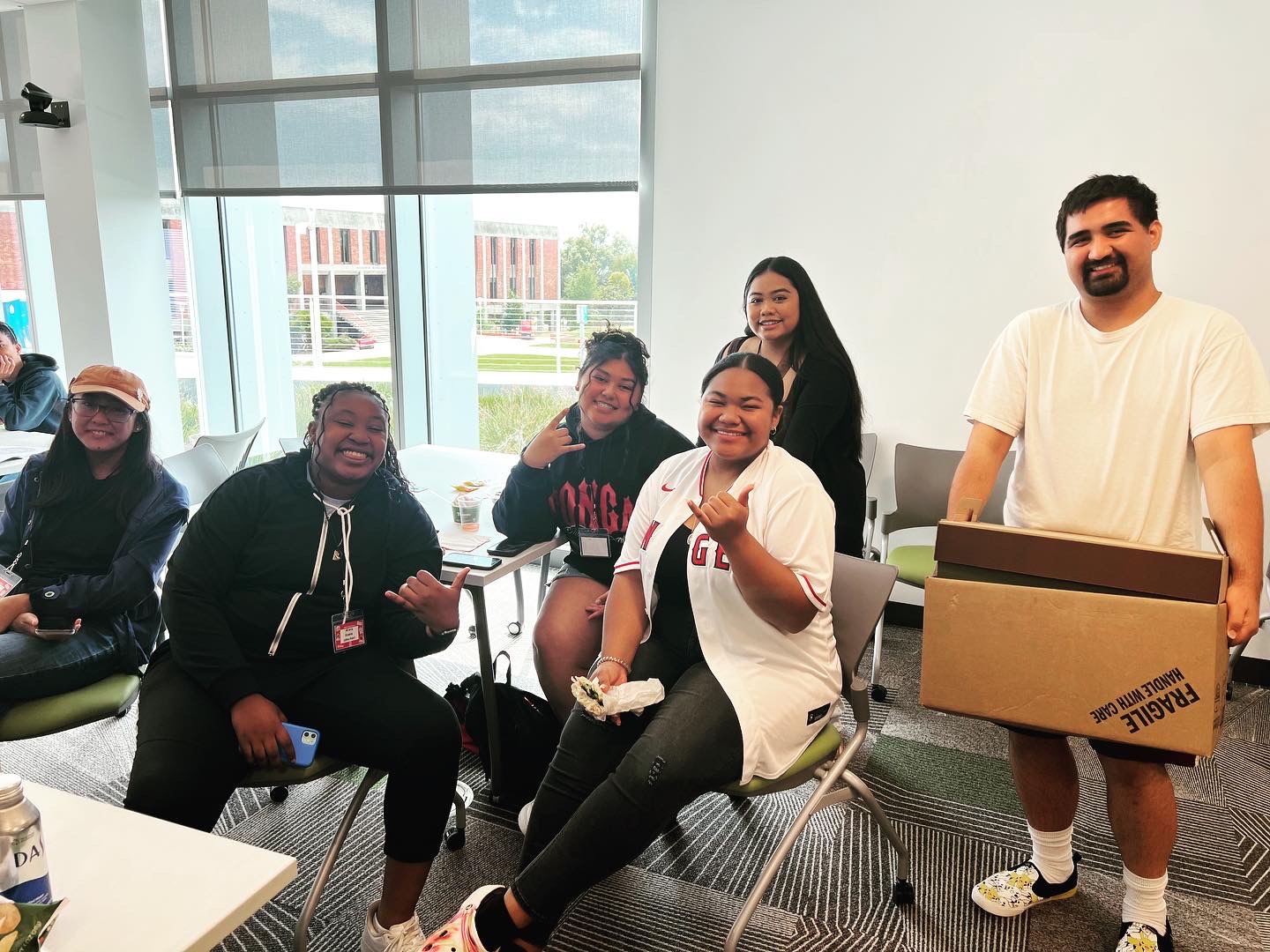 PIAA students gathered at Fall 2023 welcome, sitting around a table smiling