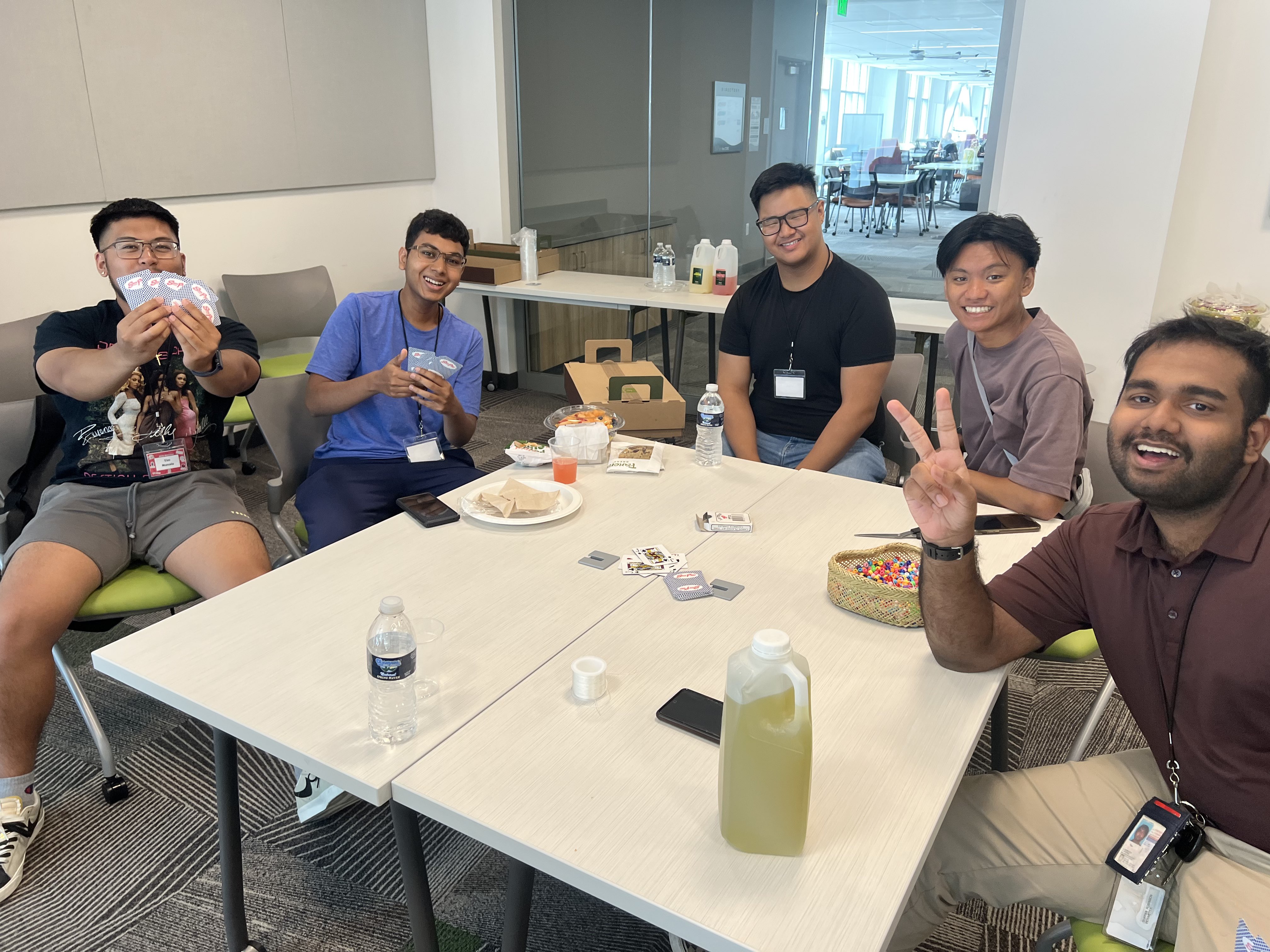 PIAA students gathered at Fall 2023 welcome, sitting around a table with different games, smiling