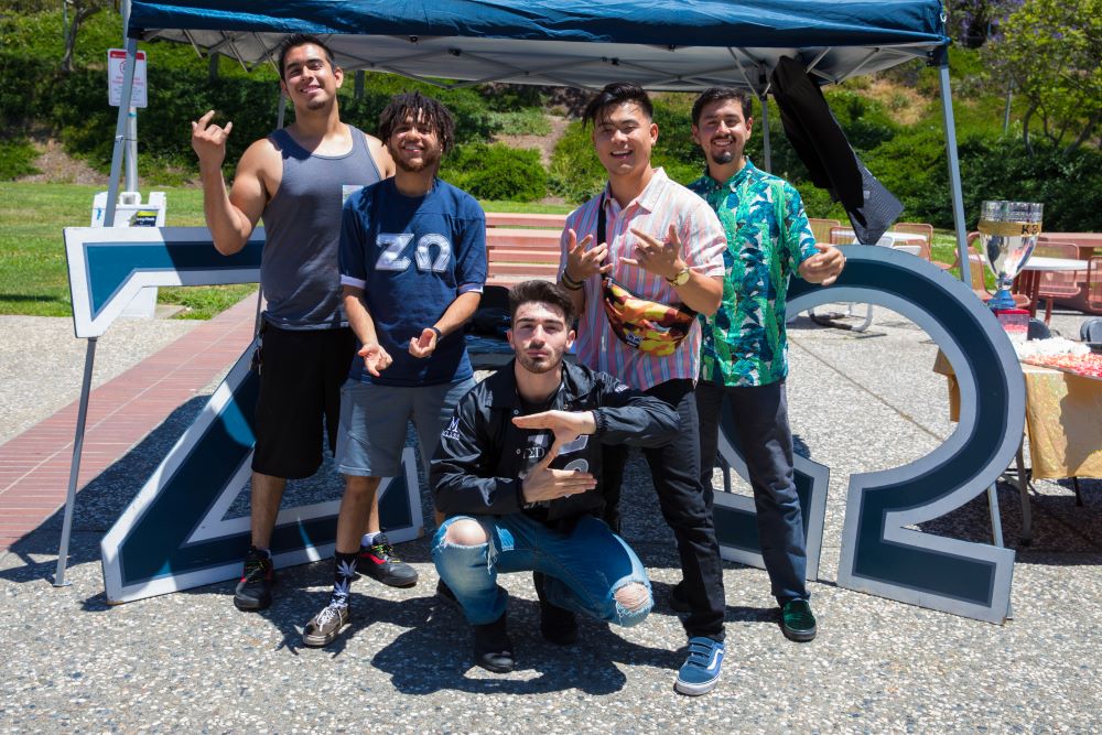 Student posing with their club signs