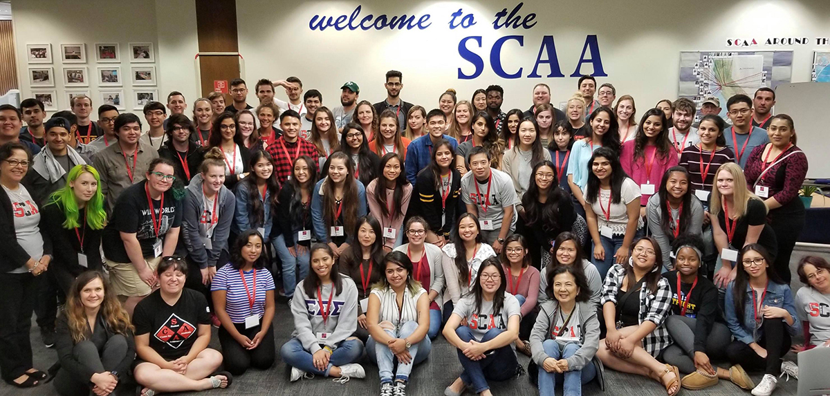 Dozens of tutors and staff smiling for a SCAA group photo