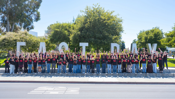 A group of SCAA employees in front of the East Bay monument letters on campus