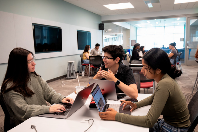 Several students in a community room in the CORE Building