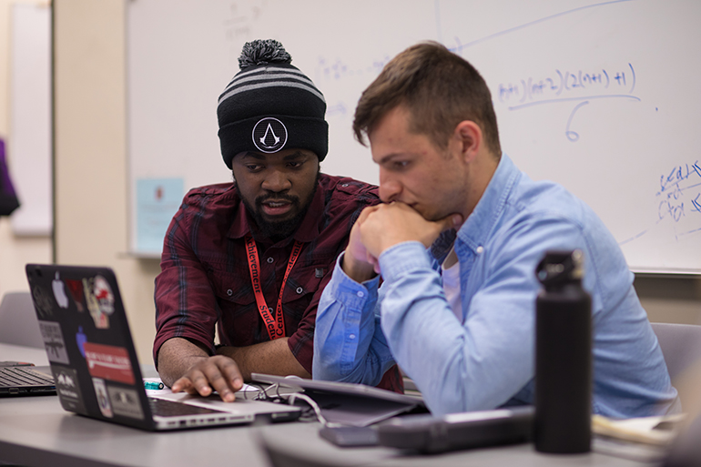 A student and a SCAA tutor working together on a laptop