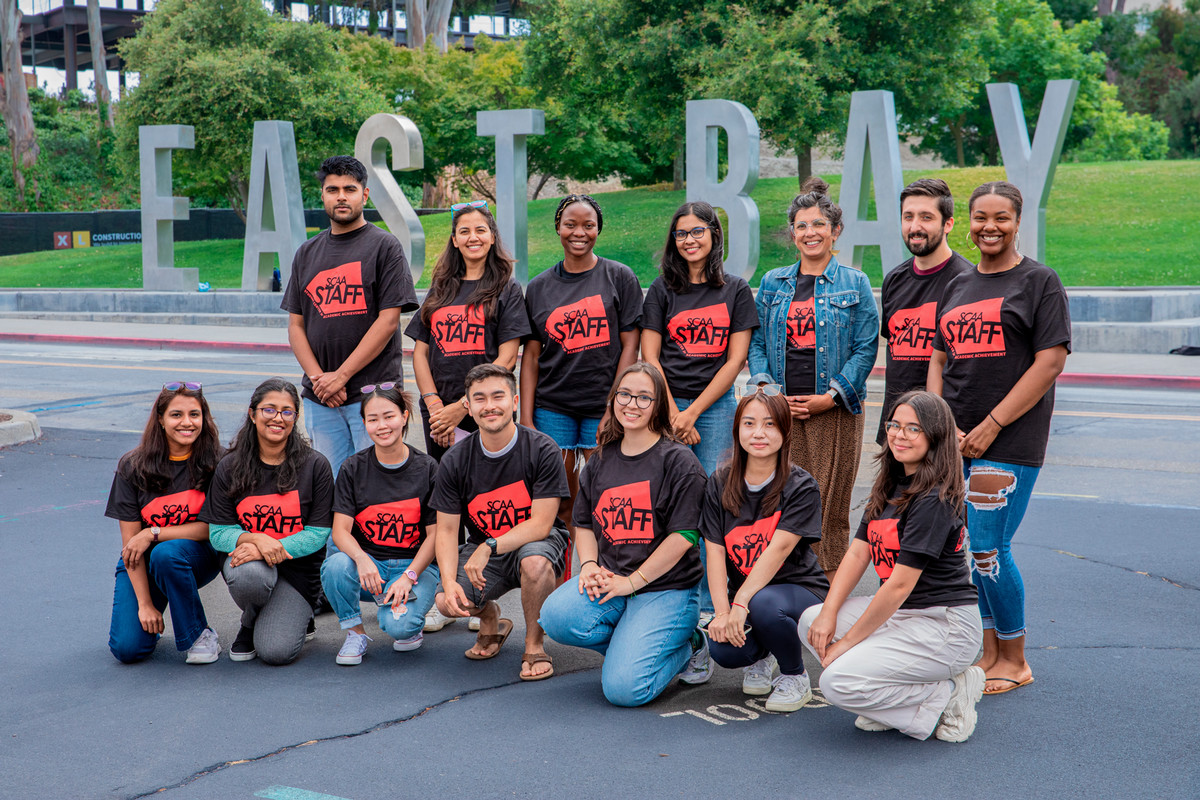 A group of students in front of the East Bay monument letters on campus