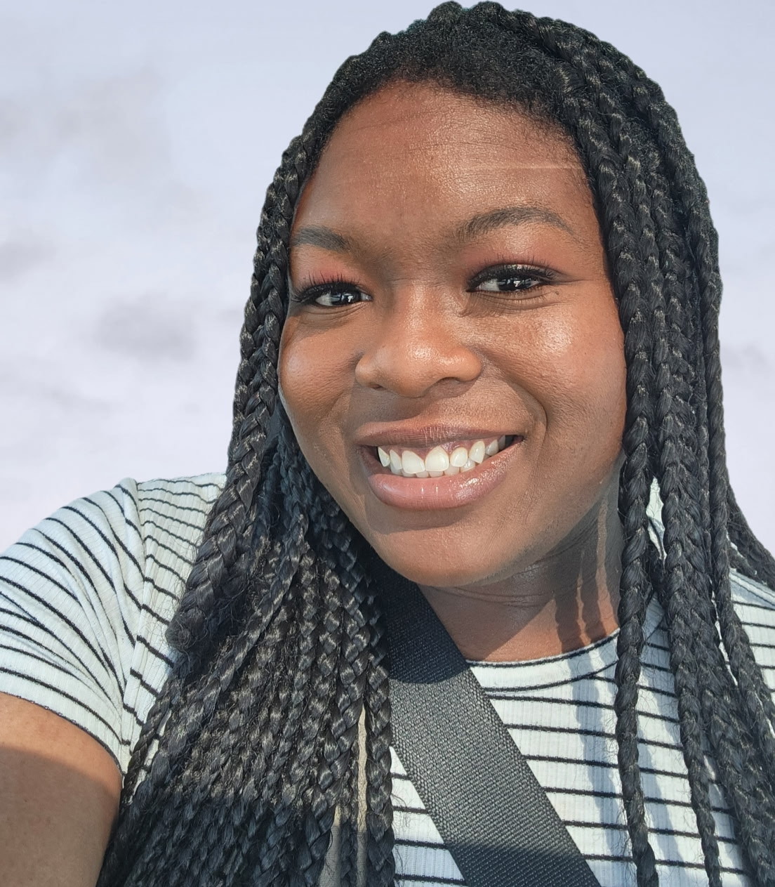 Picture of Deborah, Black female with long dark braids in front of a white background.