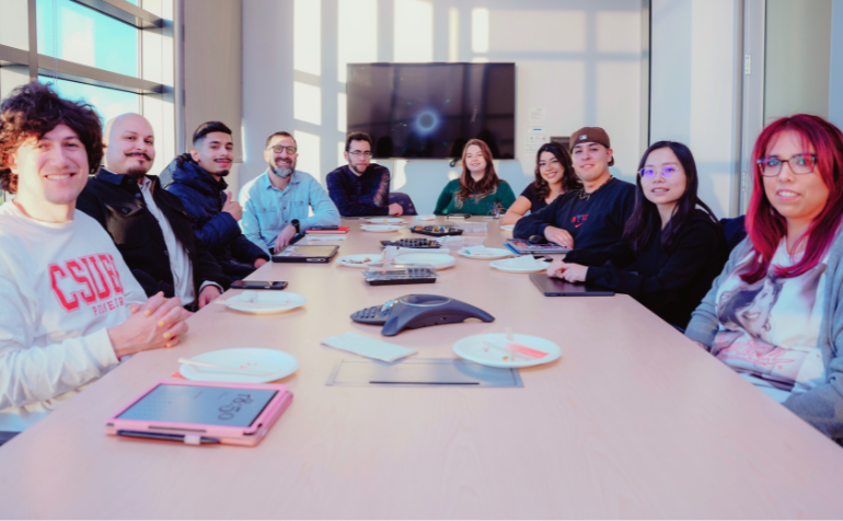 Photo of our 2025 cohort gathered around a table