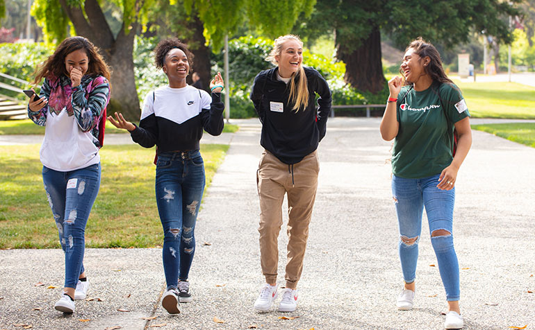 Four female students walking on campus