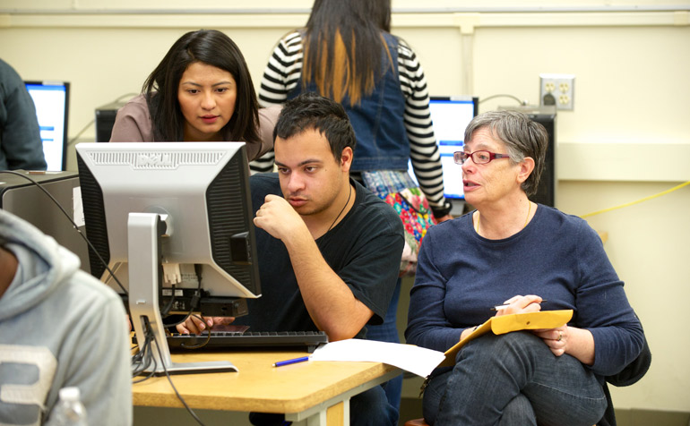 Student on Computer and Faculty sitting next to them