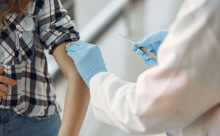 Doctor giving vaccine to person in the arm