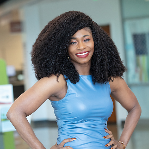 Photo of Deka Dike smiling with her hands on her hips