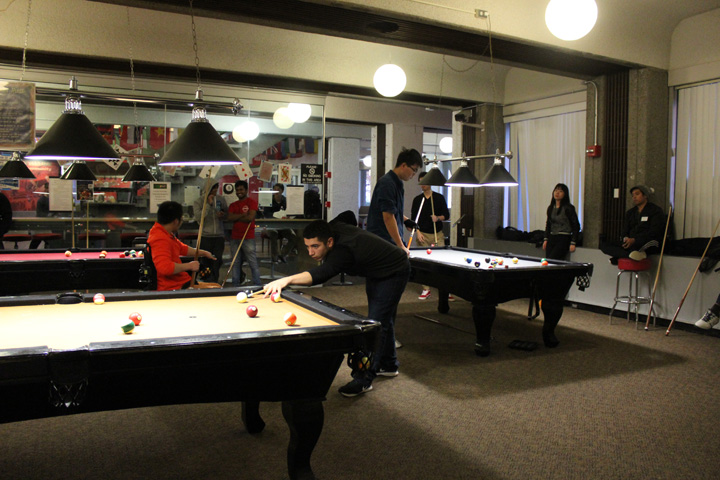 Students Sitting Around or Taking a shot on the Billiard Tables
