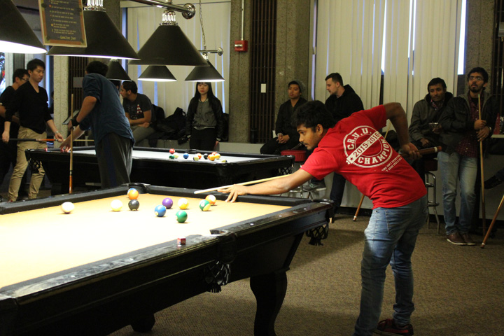 Student Getting Ready to Take a Shot on the Billiard Table