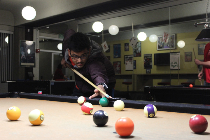Student Getting Ready to Take a shot at the ball on the Billiard Table
