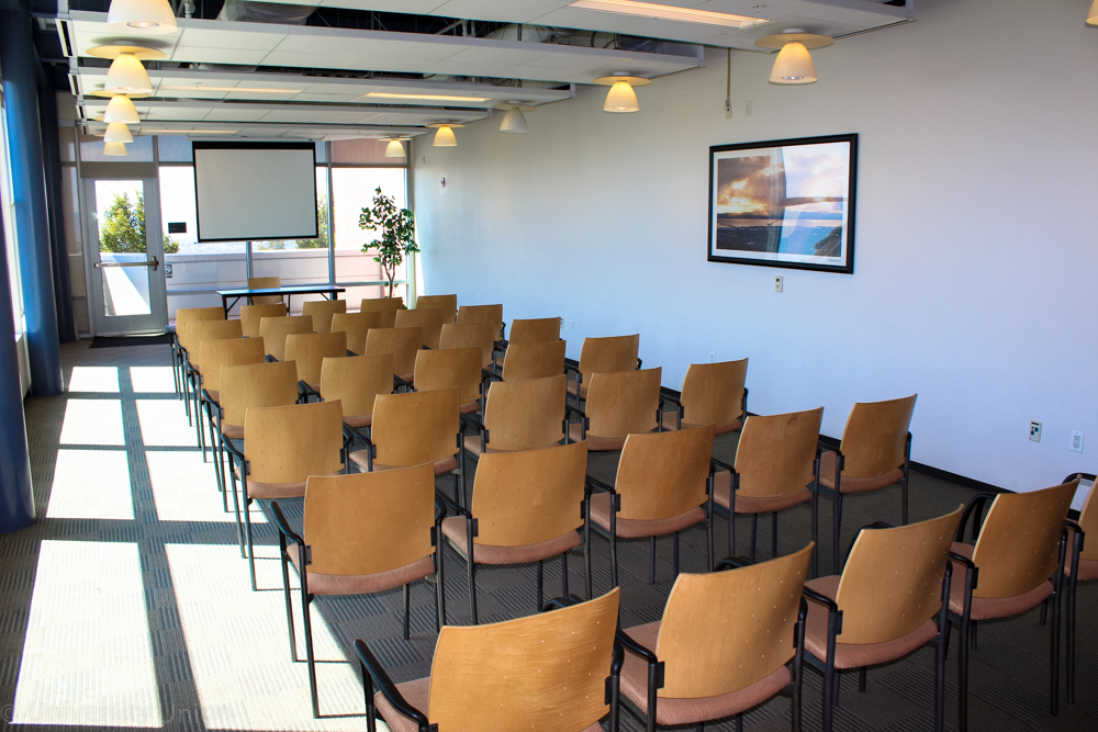 Chairs in Rows Facing Forward with One Table Facing the Back in the Front