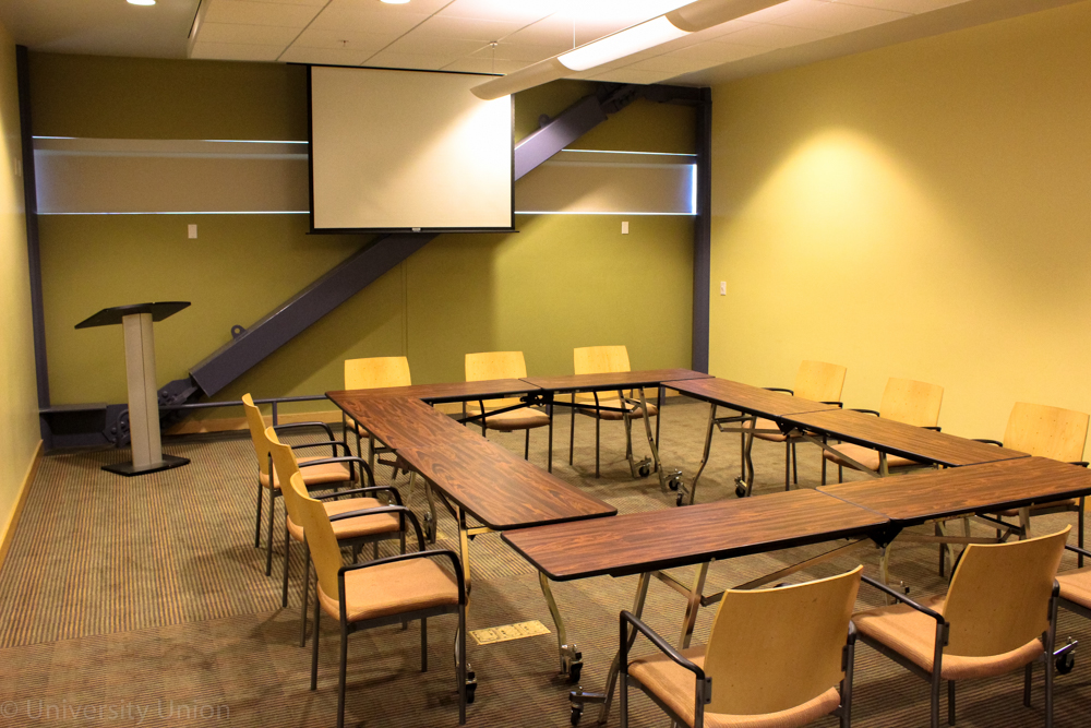Open Rectangular Table with Chairs on the Outside with Projector Screen and Podium in the Front