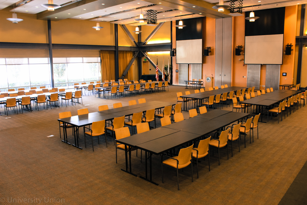 Multiple Rows of Long Rectangle Tables with Chairs on the Outside and a Podium in the Front